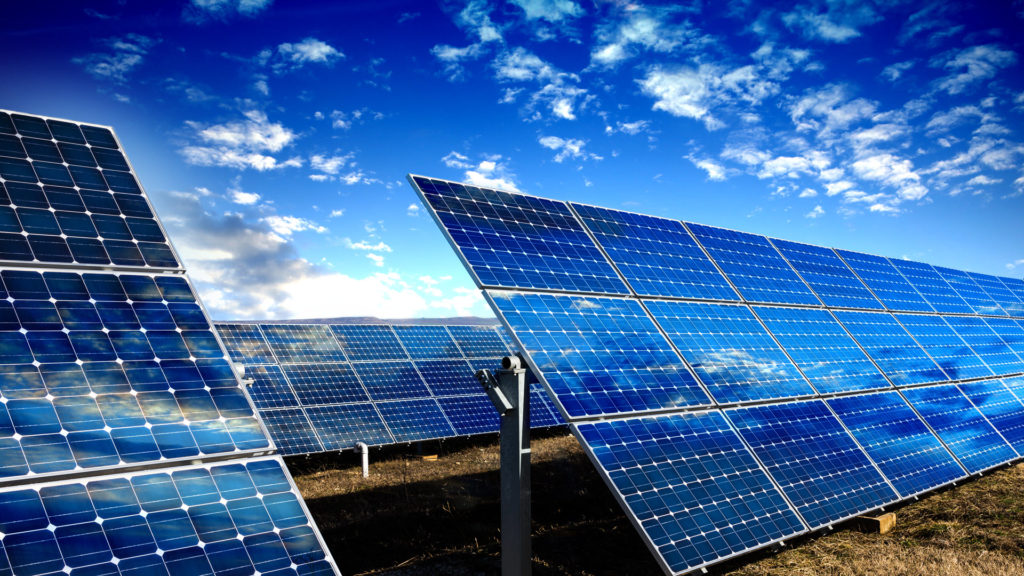 solar panels facing sun on bright day with blue sky and clouds