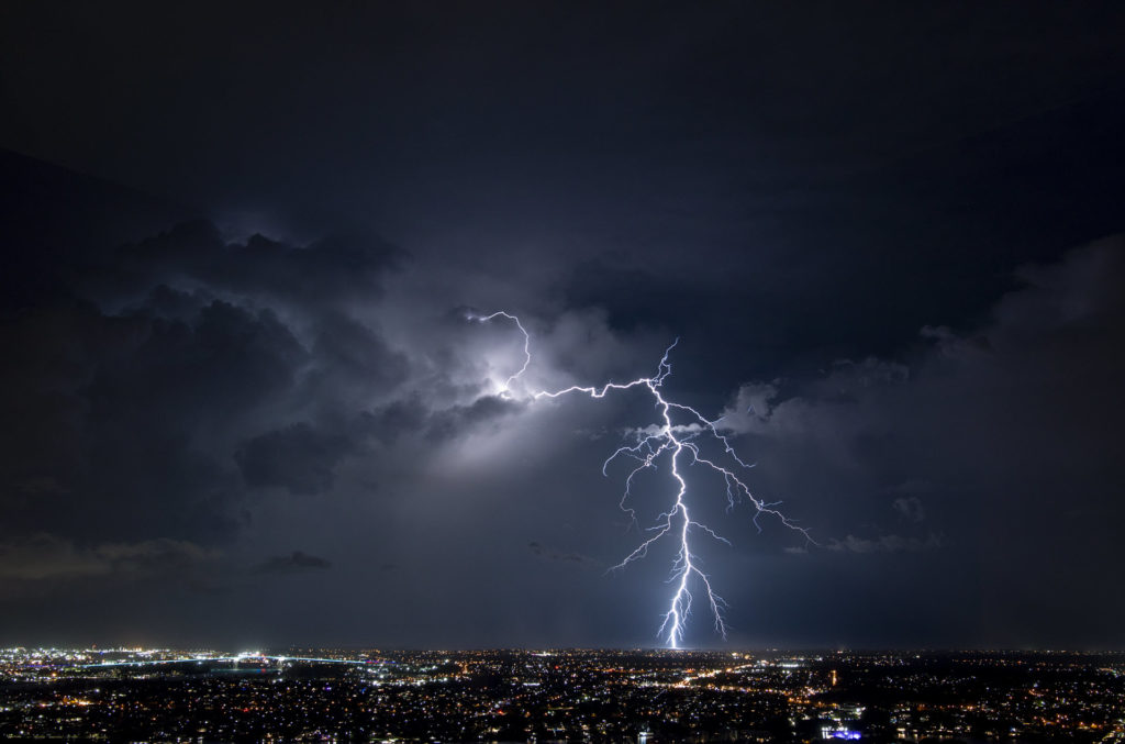 lightning over a city lit up at night