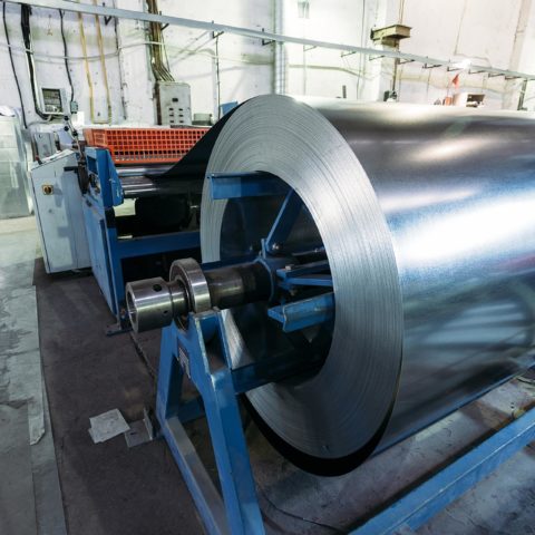 large roll of steel on a blue stand