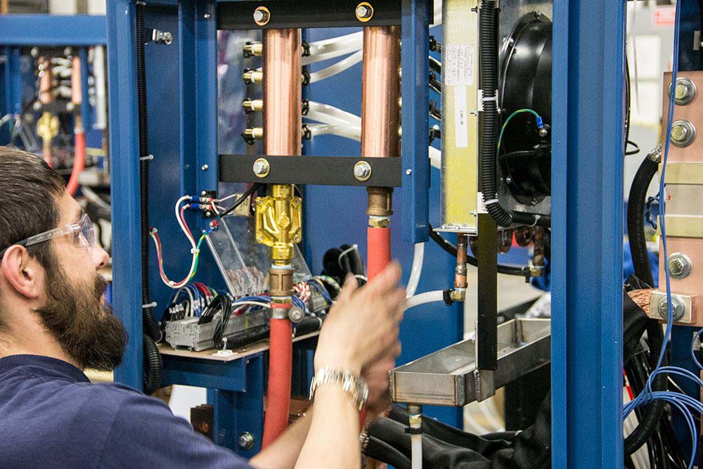 person with safety glasses performing maintenance on a rectifier