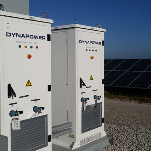 Two Dynapower solar plus storage systems side by side outside next to solar array