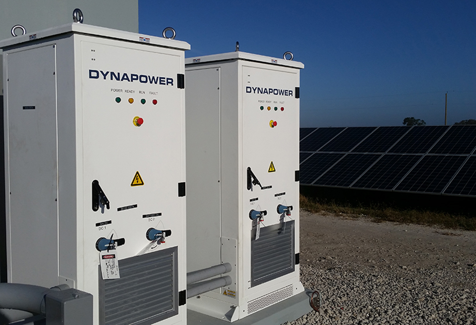 Two Dynapower solar plus storage systems side by side outside next to solar array