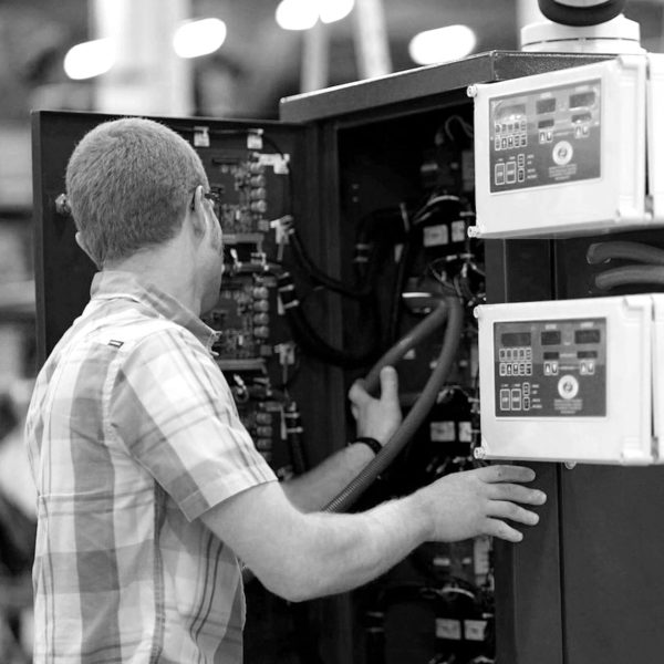 black and white, dynapower employee working on a machine